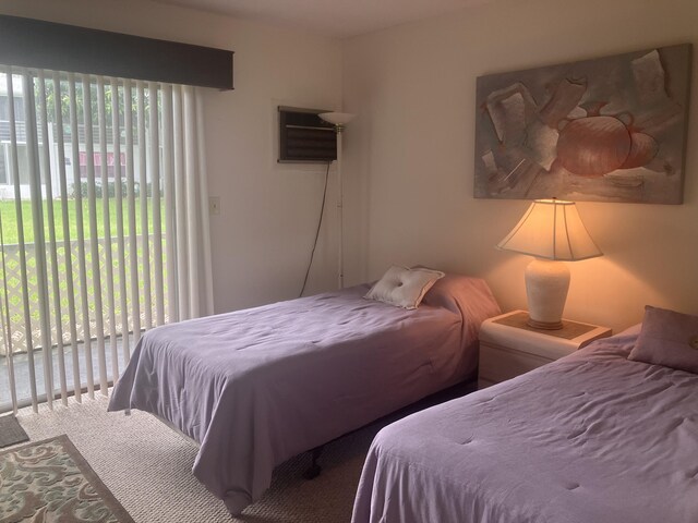carpeted bedroom featuring access to outside and an AC wall unit