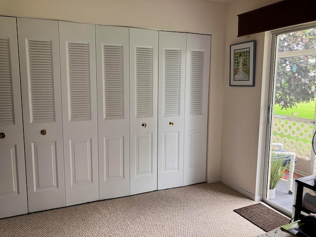 unfurnished bedroom with light carpet, a closet, and baseboards