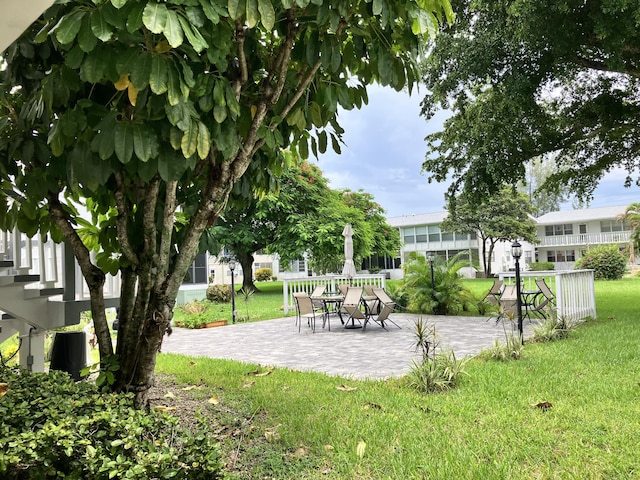 view of home's community featuring a lawn and a patio area