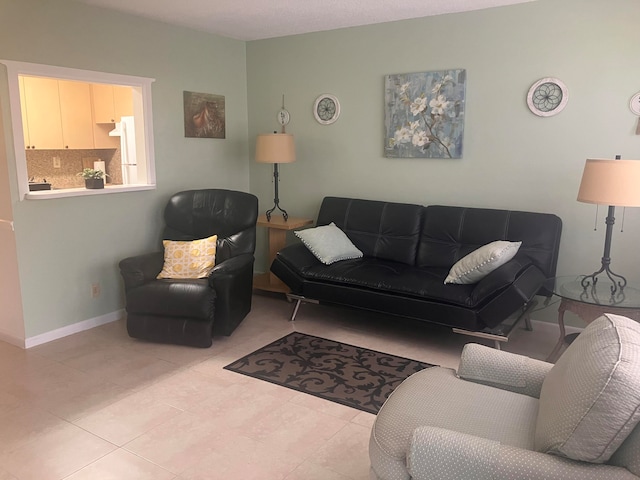 living area with baseboards and tile patterned floors