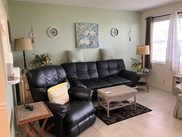 living area with light tile patterned floors, a textured ceiling, and baseboards