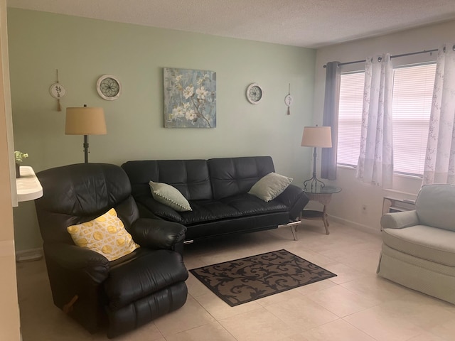 living area featuring a textured ceiling, tile patterned flooring, and baseboards