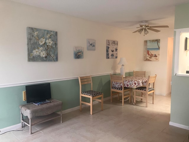 dining space featuring tile patterned floors, a ceiling fan, and baseboards