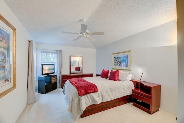 carpeted bedroom featuring ceiling fan, vaulted ceiling, and a textured ceiling