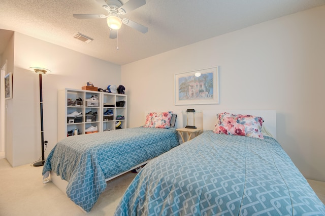 carpeted bedroom featuring a textured ceiling and ceiling fan