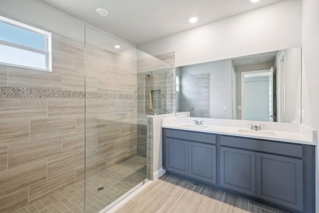 bathroom featuring vanity, hardwood / wood-style floors, and tiled shower