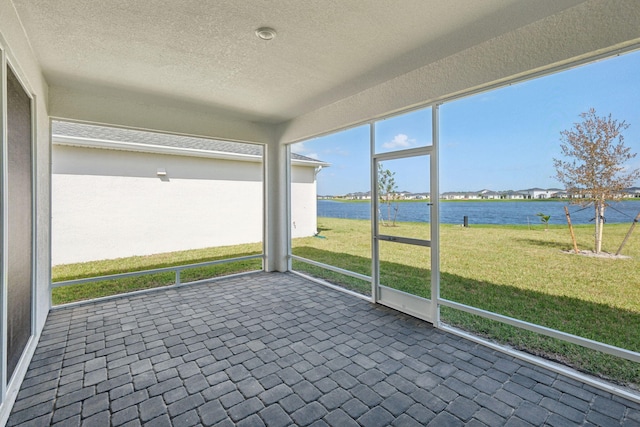 unfurnished sunroom featuring a water view