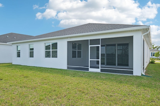 back of property with a sunroom and a yard