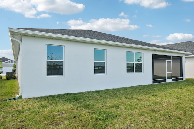 back of property featuring a sunroom and a yard