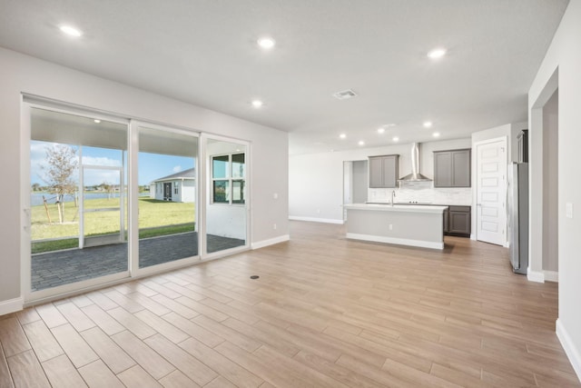 unfurnished living room featuring light wood-type flooring and sink