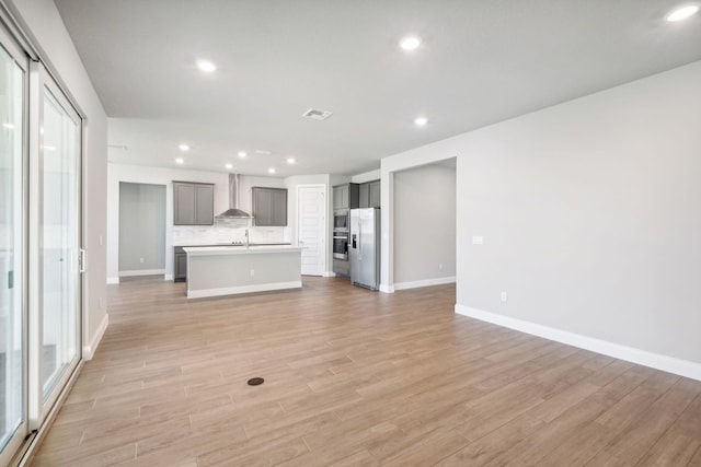 unfurnished living room with light hardwood / wood-style floors and sink