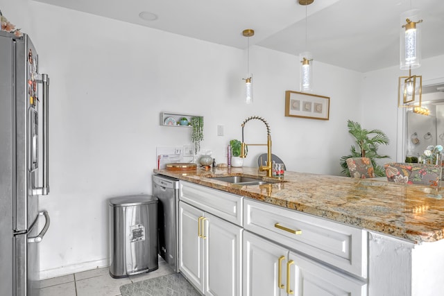 kitchen featuring stainless steel appliances, hanging light fixtures, white cabinetry, a sink, and a peninsula