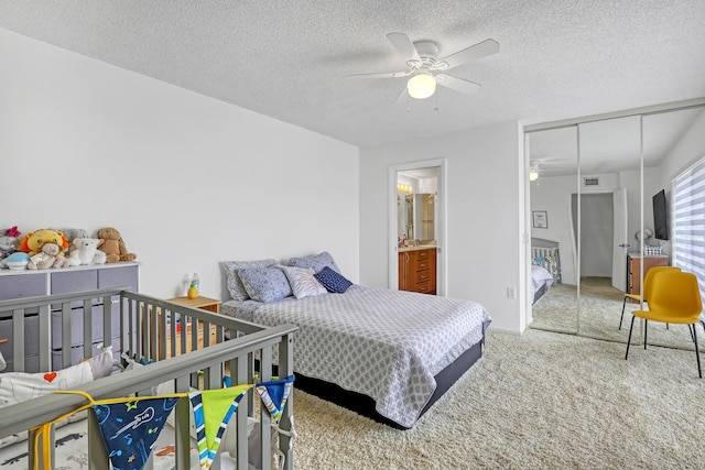 carpeted bedroom featuring a ceiling fan, a closet, and a textured ceiling