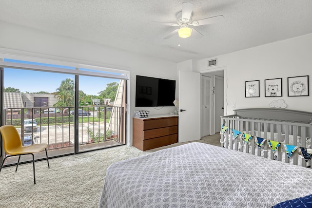 carpeted bedroom featuring a textured ceiling, ceiling fan, visible vents, and access to exterior