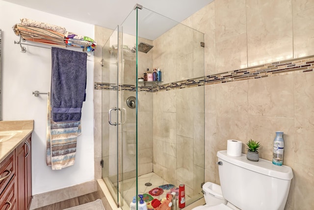 full bathroom with a stall shower, vanity, and toilet