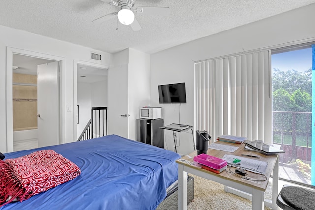 bedroom featuring a textured ceiling, visible vents, and a ceiling fan