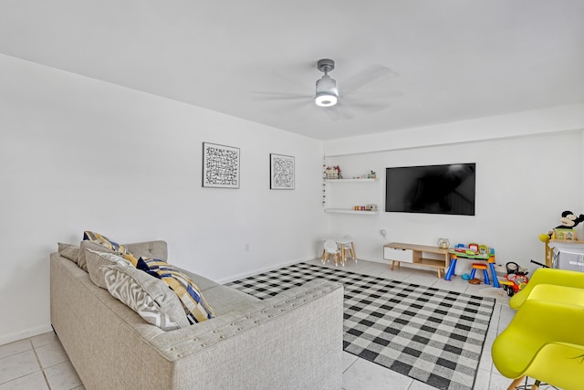 living room with ceiling fan, baseboards, and light tile patterned floors