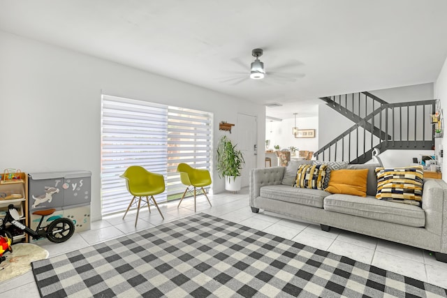 living area with stairs, light tile patterned flooring, and a ceiling fan