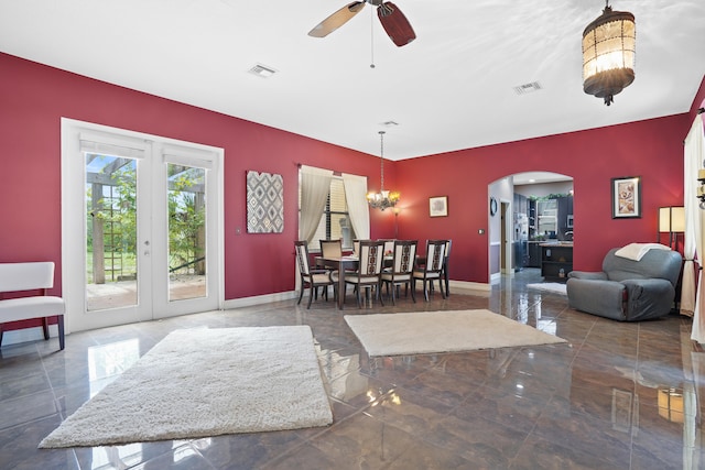 interior space with ceiling fan with notable chandelier and dark tile patterned floors