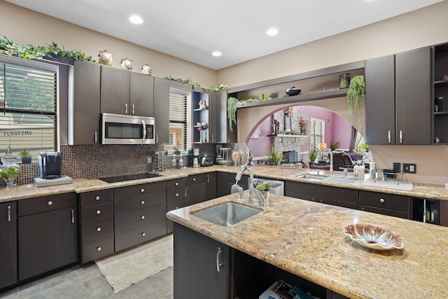 kitchen featuring backsplash, light tile patterned flooring, black electric stovetop, and sink