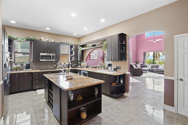 kitchen featuring stainless steel appliances, sink, a center island with sink, ceiling fan, and light tile patterned flooring