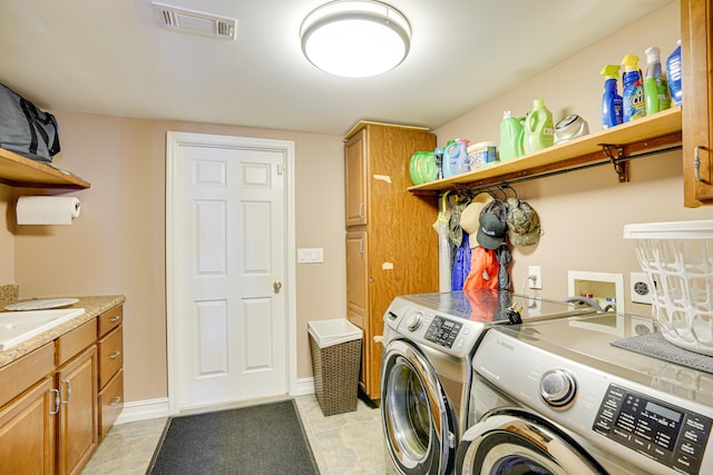 clothes washing area with independent washer and dryer, light tile patterned floors, and cabinets