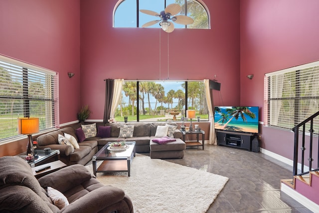 living room with a towering ceiling, tile patterned floors, and ceiling fan