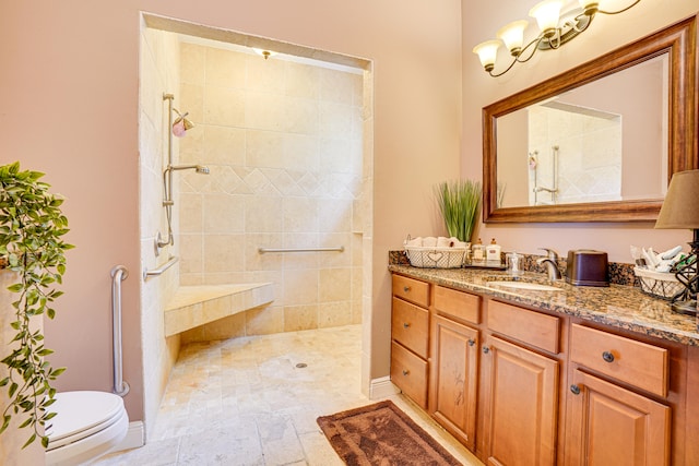 bathroom featuring toilet, vanity, tiled shower, and tile patterned floors