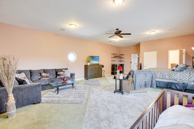 carpeted bedroom with ceiling fan and a textured ceiling