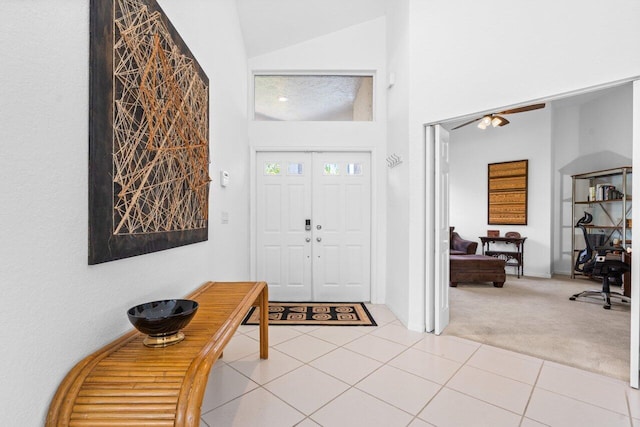 tiled foyer featuring ceiling fan and vaulted ceiling