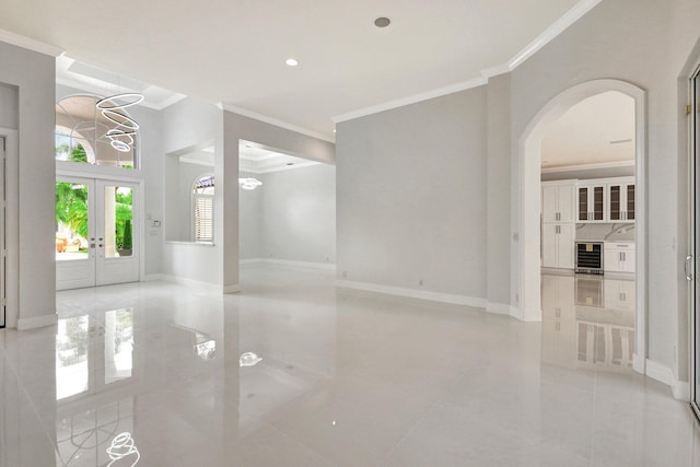 spare room with crown molding, french doors, and light tile patterned flooring