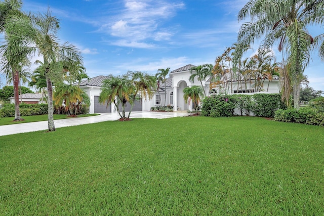 mediterranean / spanish home featuring a front lawn and a garage