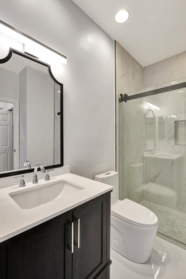 bathroom with vanity, a shower with shower door, and toilet