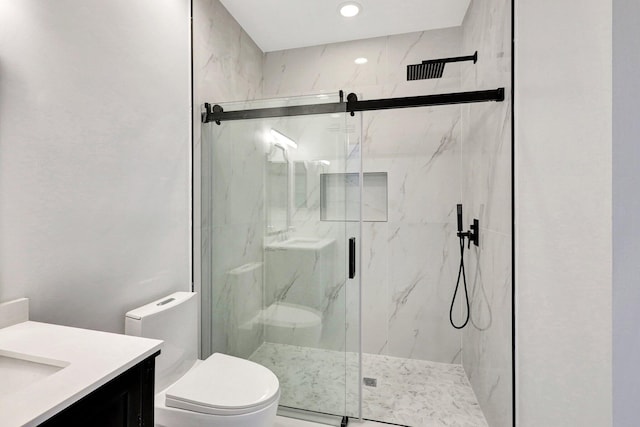 bathroom featuring vanity, a shower with shower door, and toilet