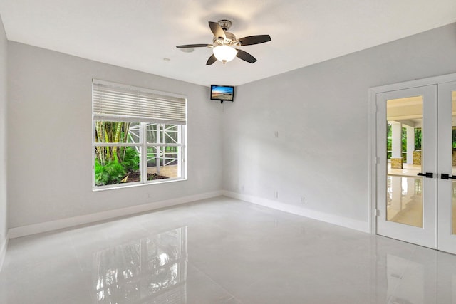 tiled spare room featuring french doors, a wealth of natural light, and ceiling fan