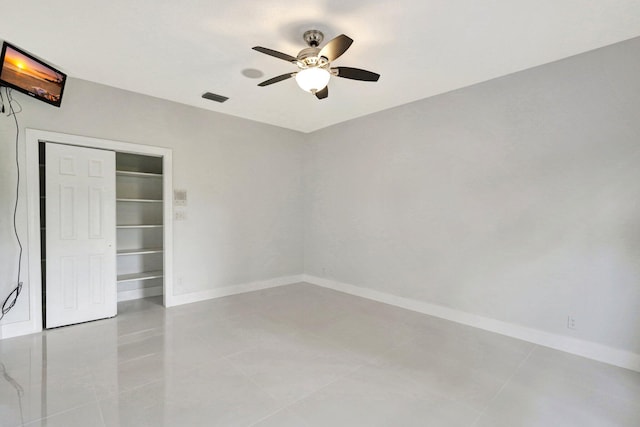 tiled empty room featuring ceiling fan