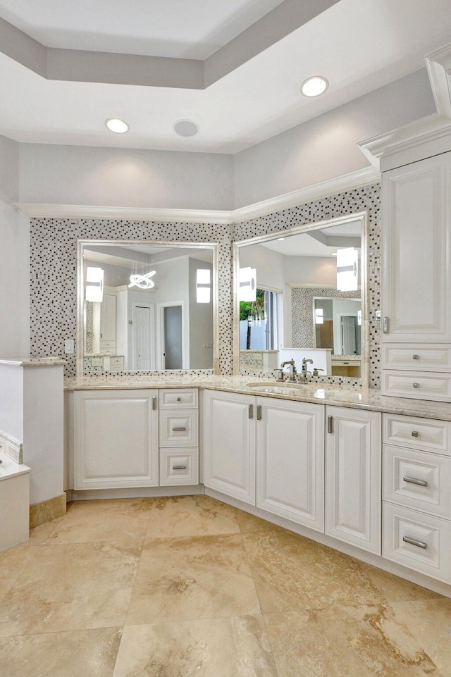 bathroom featuring vanity, an inviting chandelier, and crown molding