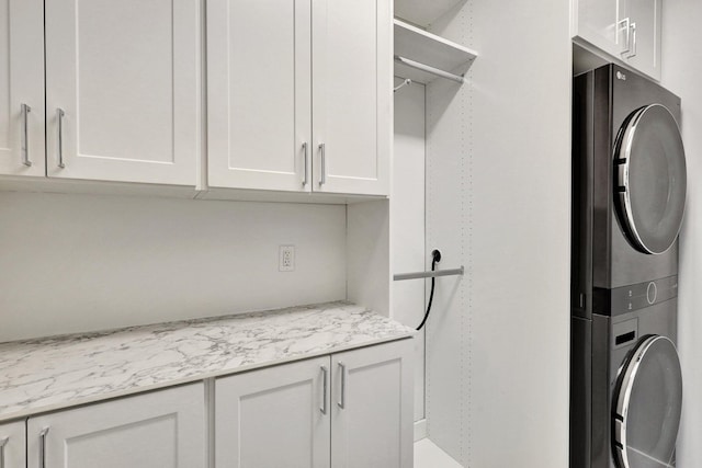 laundry area featuring cabinets and stacked washer and dryer