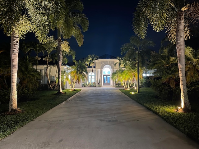 view of front of property with a lawn and french doors