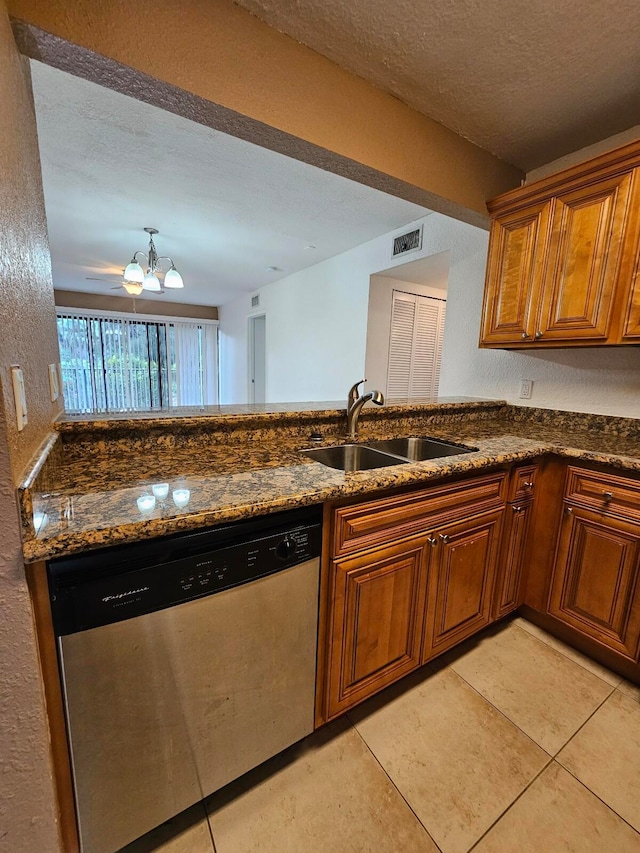 kitchen featuring sink, dark stone counters, light tile patterned flooring, and dishwasher