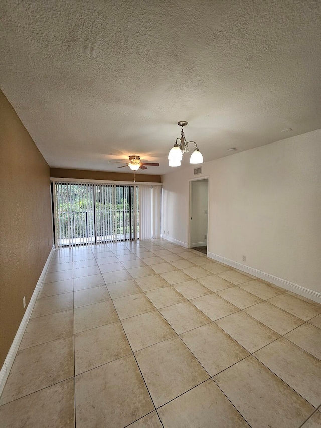 tiled spare room with a textured ceiling and ceiling fan with notable chandelier