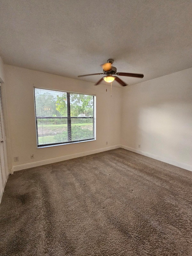 carpeted spare room featuring a textured ceiling and ceiling fan