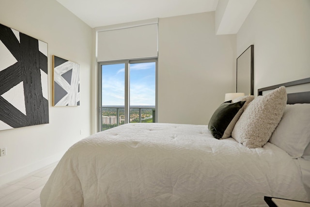 bedroom featuring light wood-type flooring and access to outside