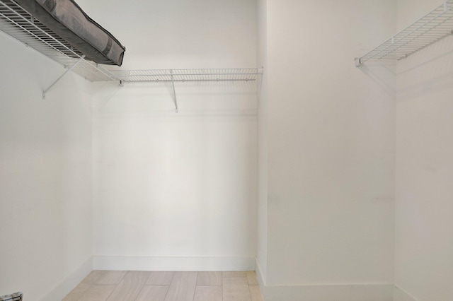 spacious closet featuring light tile patterned floors