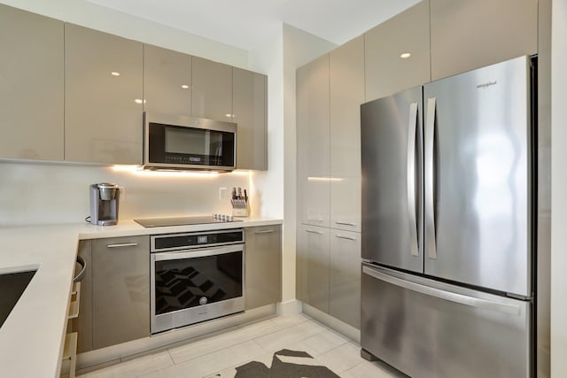 kitchen with light tile patterned floors, gray cabinets, and stainless steel appliances