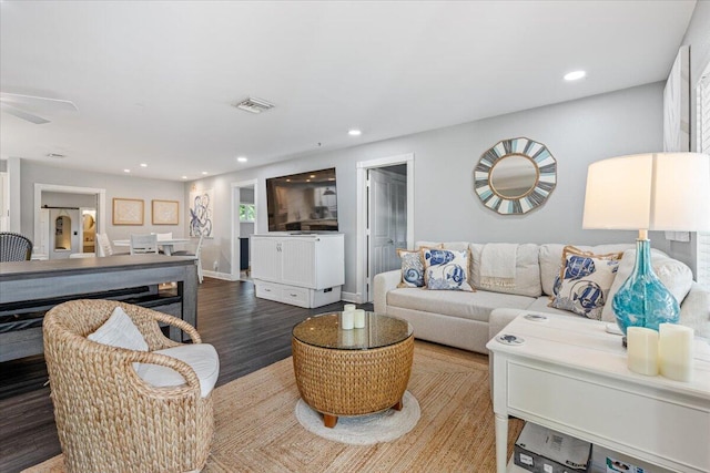 living room with wood-type flooring and ceiling fan