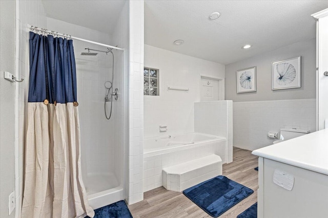 bathroom with vanity, a textured ceiling, wood-type flooring, and shower with separate bathtub