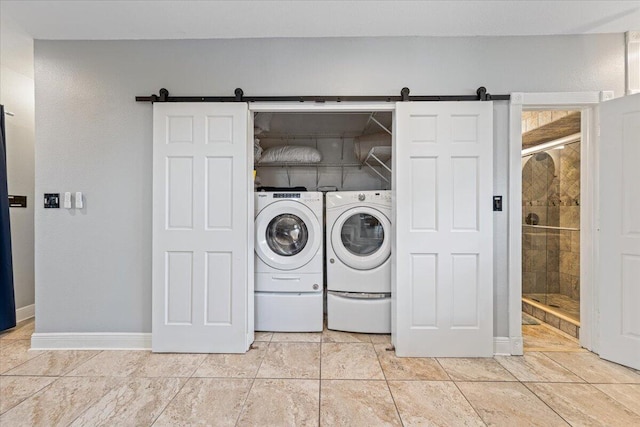 washroom featuring washing machine and clothes dryer and a barn door