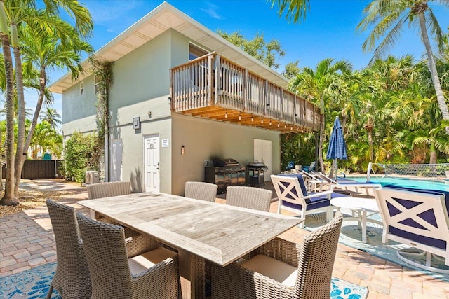 view of patio featuring a fenced in pool and a balcony