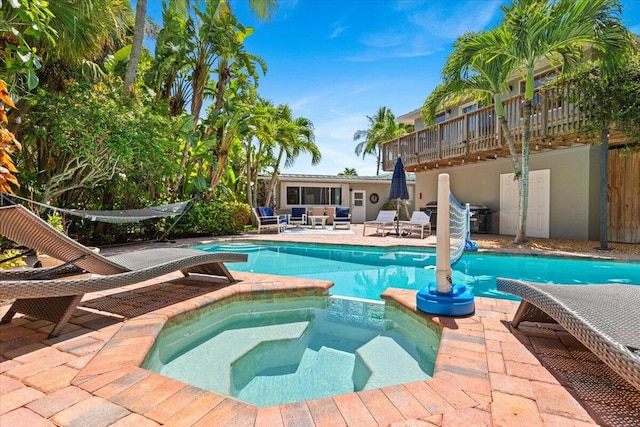 view of pool featuring a patio area and an in ground hot tub